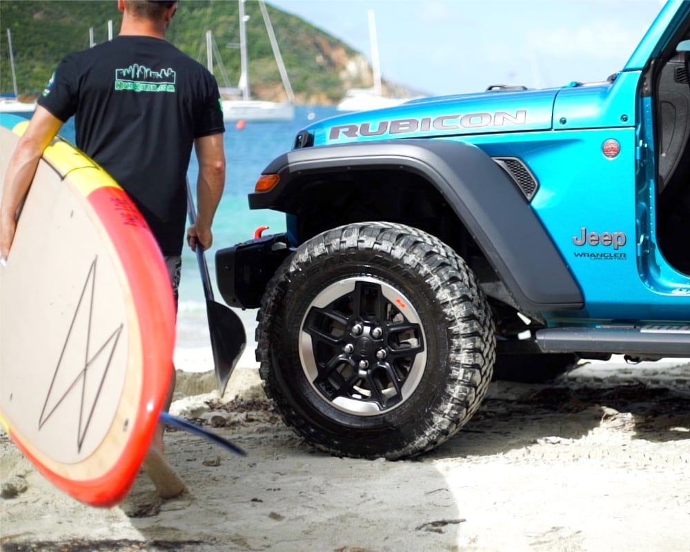 man carrying SUP paddle board during Jeep Tour in Saint John Virgin Islands